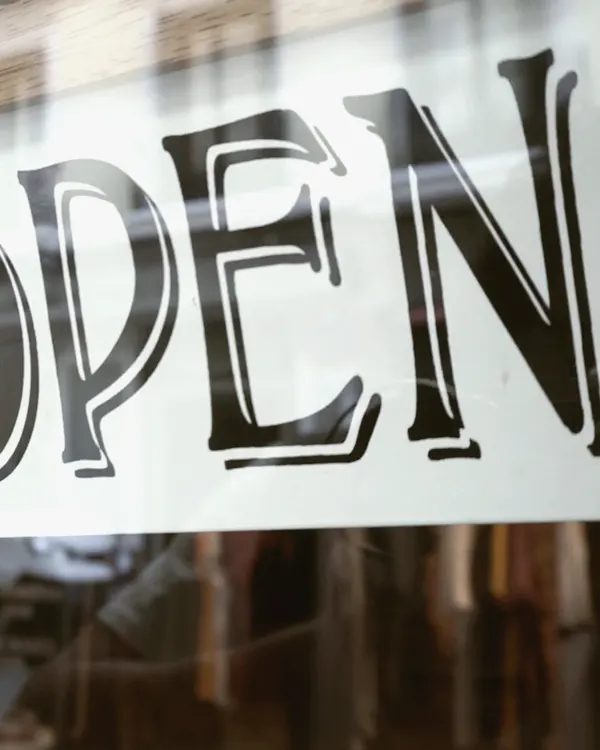 Une pancarte « Open » retournée dans une vitrine